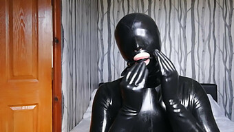 Eine Devote Latexfrau Wird Mit Verbundenen Augen Verführt, Geknebelt Und Maskiert.